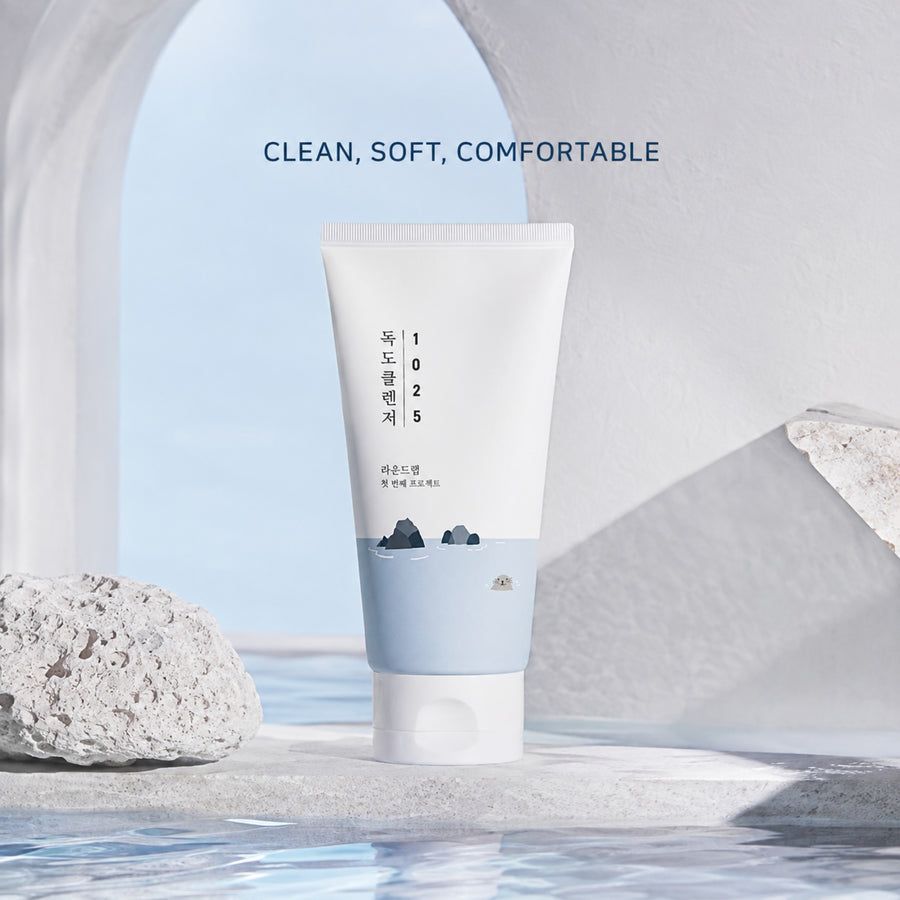Kit Hidratación Round Lab: limpiador 1025 Dokdo Cleanser junto a un arco de piedra y agua