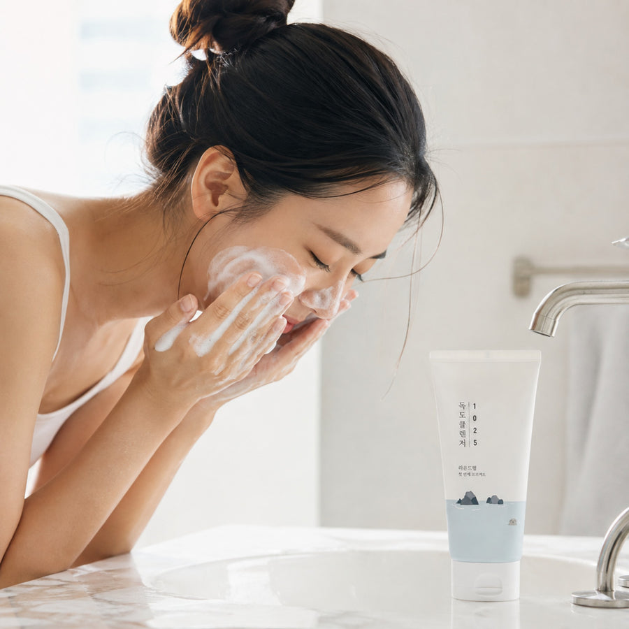 Mujer lavándose el rostro con el limpiador espumoso 1025 Dokdo Cleanser del Kit Hidratación Round Lab