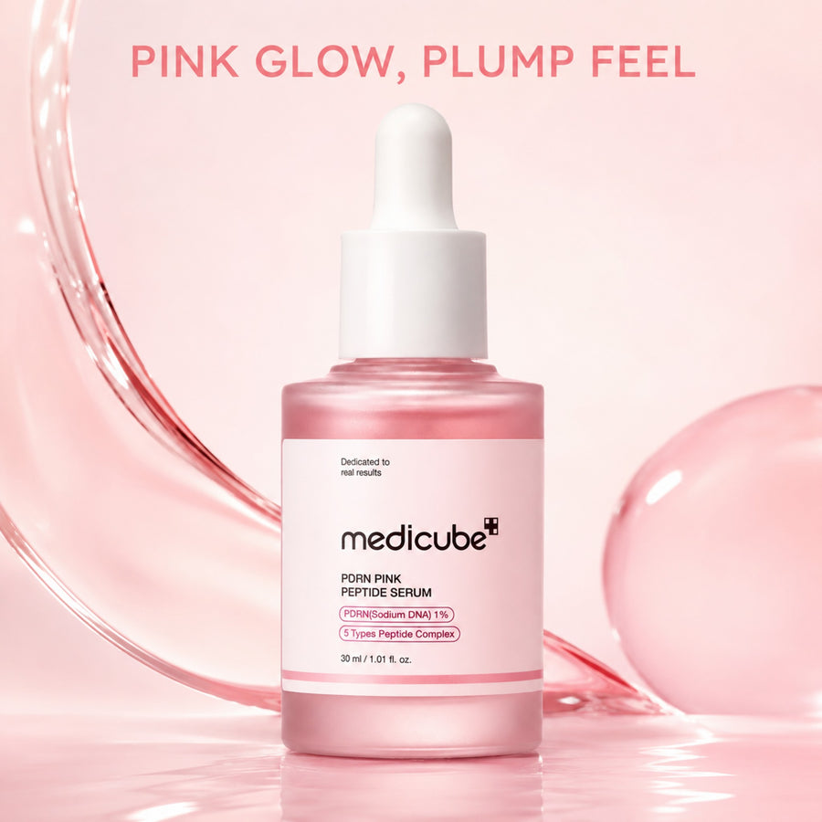 Kit Pink Glow MEDICUBE: sérum PDRN Pink Peptide Serum sobre una superficie rosa con agua