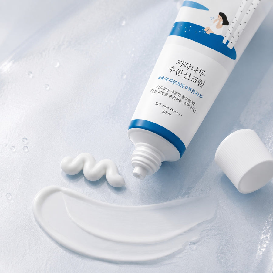 Kit Hidratación Round Lab: tubo abierto del protector solar Birch Juice con su textura en crema