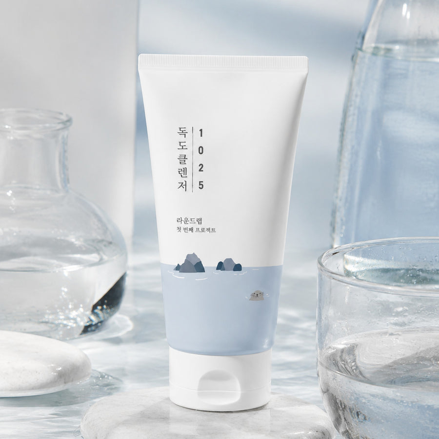 Kit Hidratación Round Lab: limpiador 1025 Dokdo Cleanser entre recipientes de cristal con agua